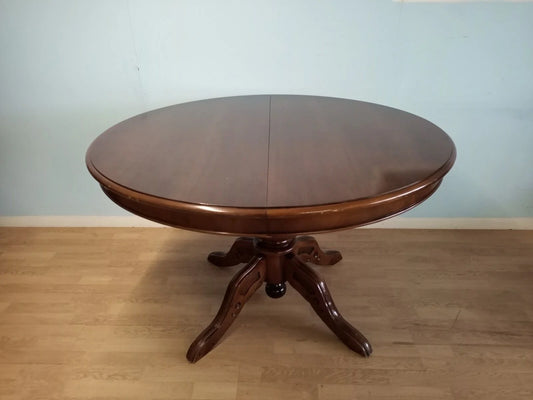Extendable round Louis Philippe style wooden table with pedestal base and carved legs for a vintage 1970s home