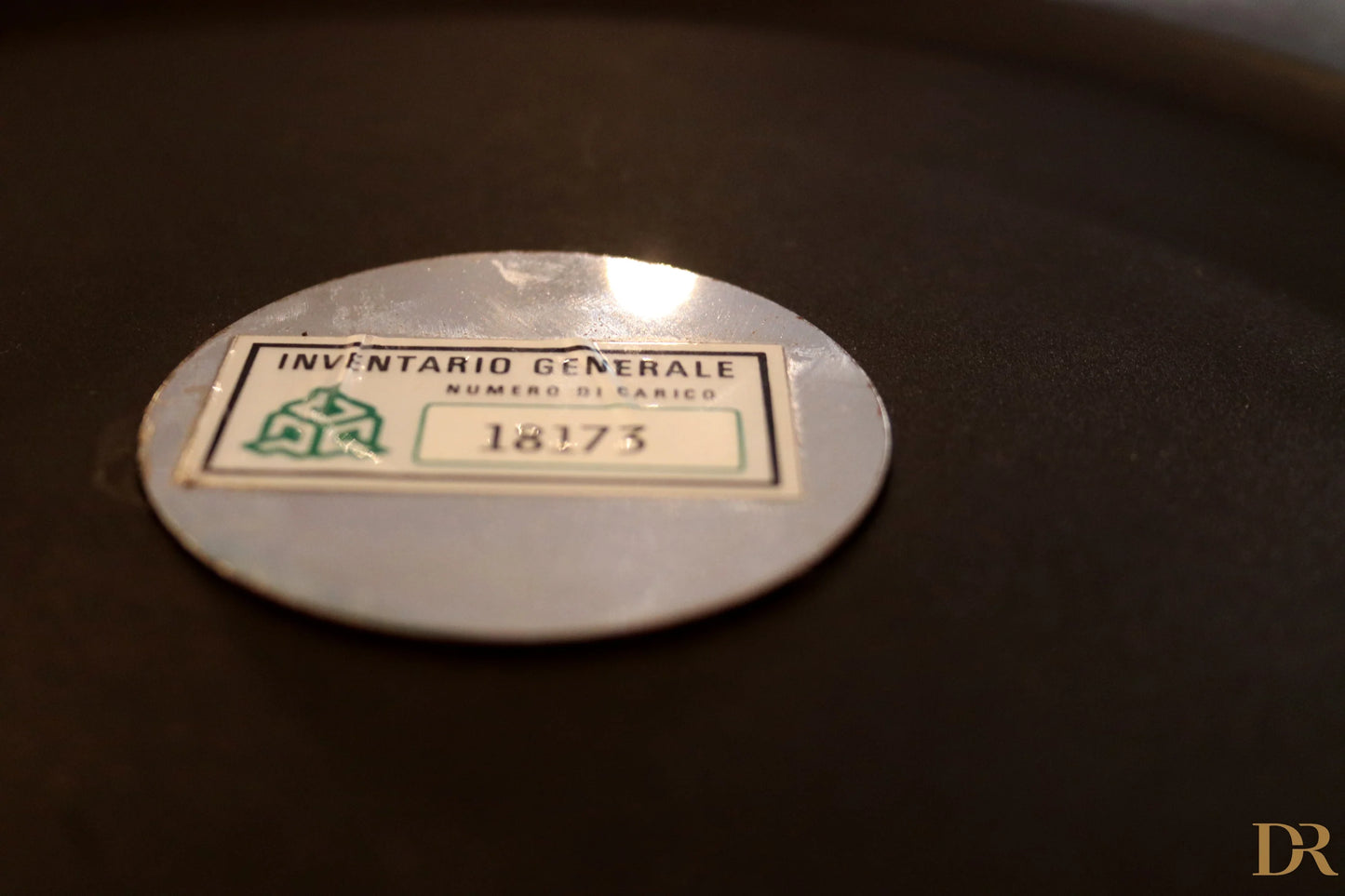 Silver oval inventory label with green and black text on Velca Paolo Orlandini and Velca Milano coat hangers.