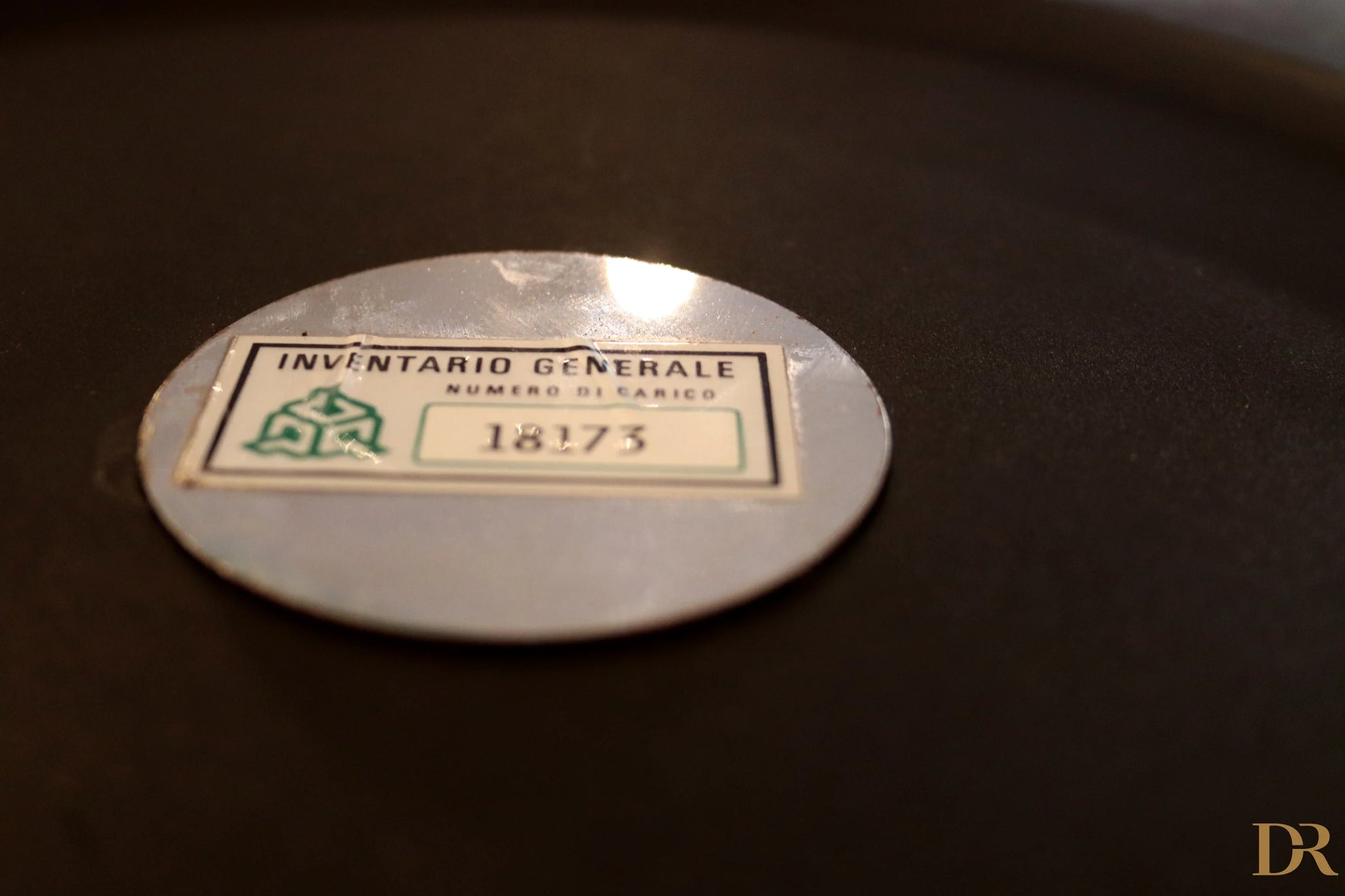 Silver oval inventory label with green and black text on Velca Paolo Orlandini and Velca Milano coat hangers.
