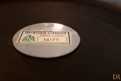 Silver oval inventory label with green and black text on Velca Paolo Orlandini and Velca Milano coat hangers.
