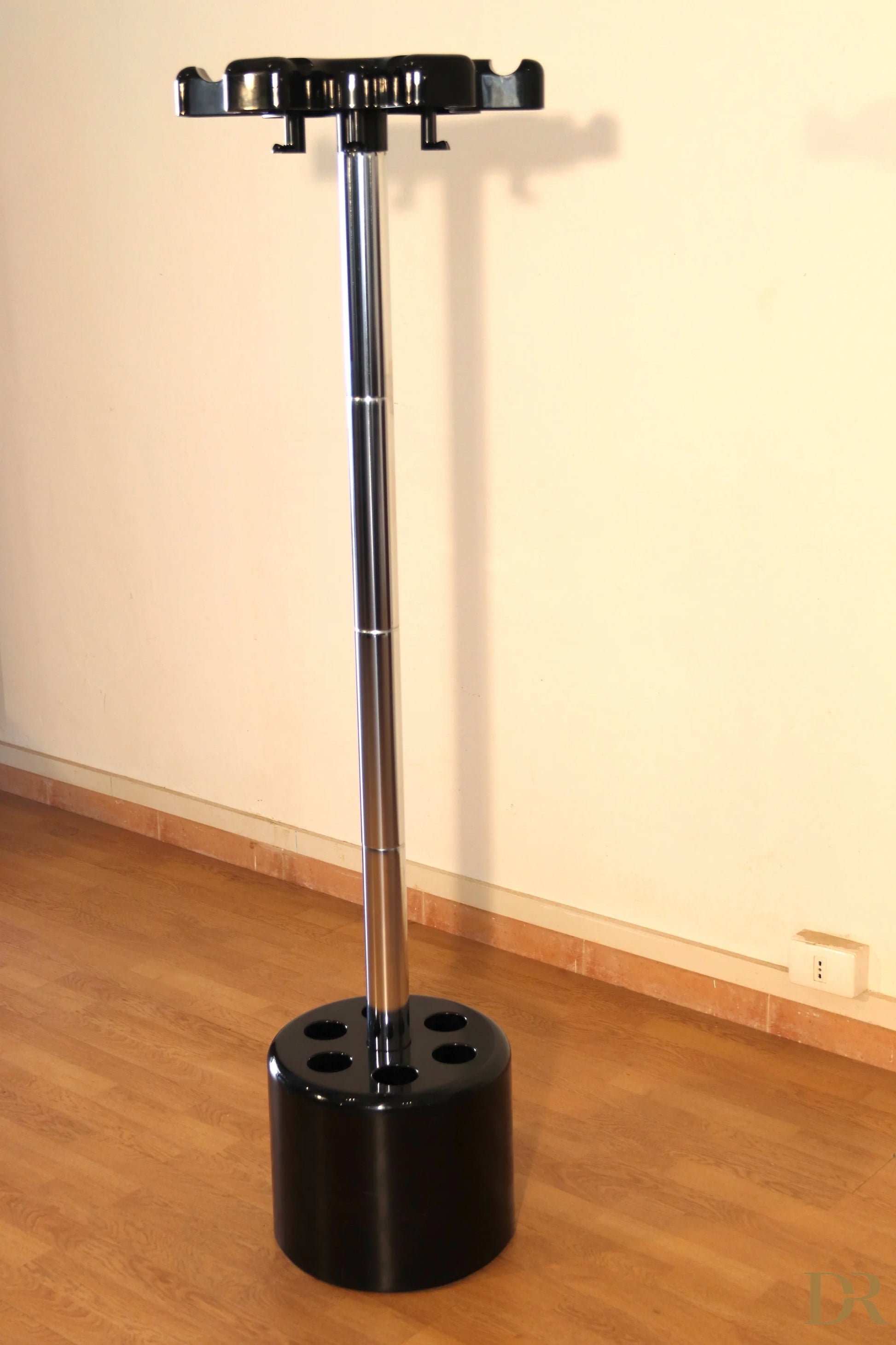 Velca coat stand in black plastic with central chrome pole and circular base designed by Paolo Orlandini Velca Milano