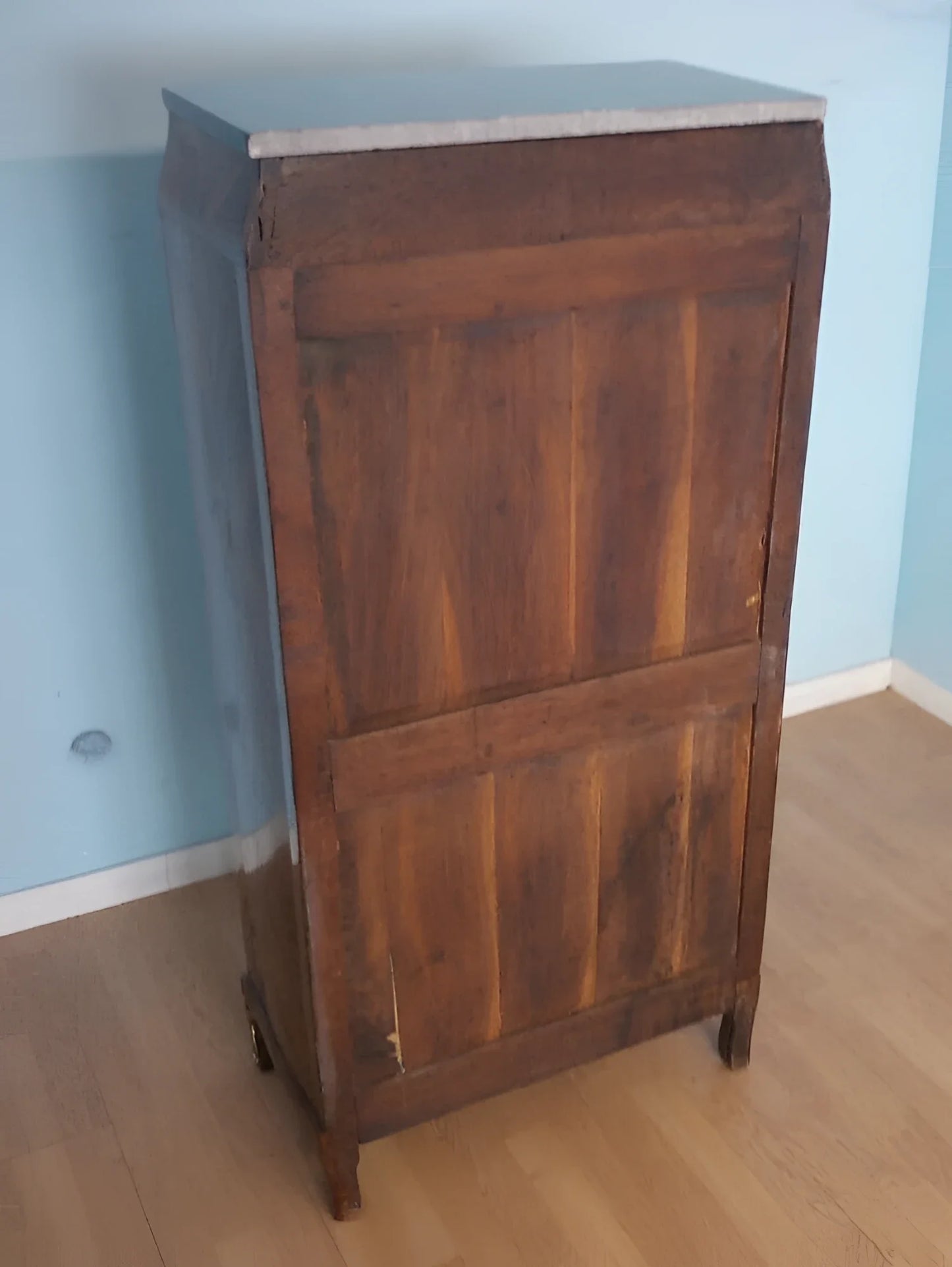 Cassettiera secrétaire luigi xvi in legno con ante a pannelli e marmo contro parete blu