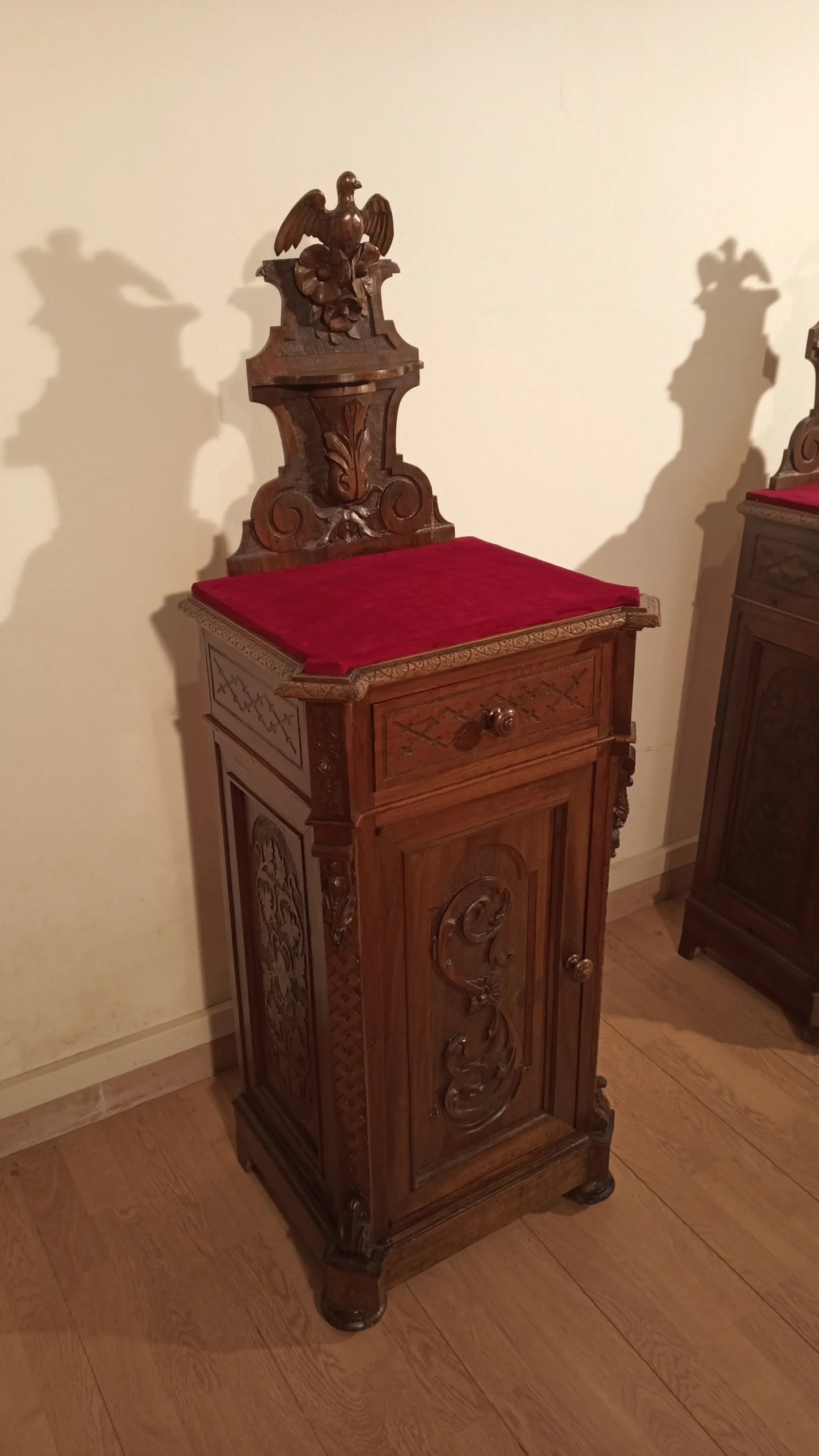 Italian walnut chest of drawers with red cushion on top in a set of three 19th century nightstands and chest of drawers