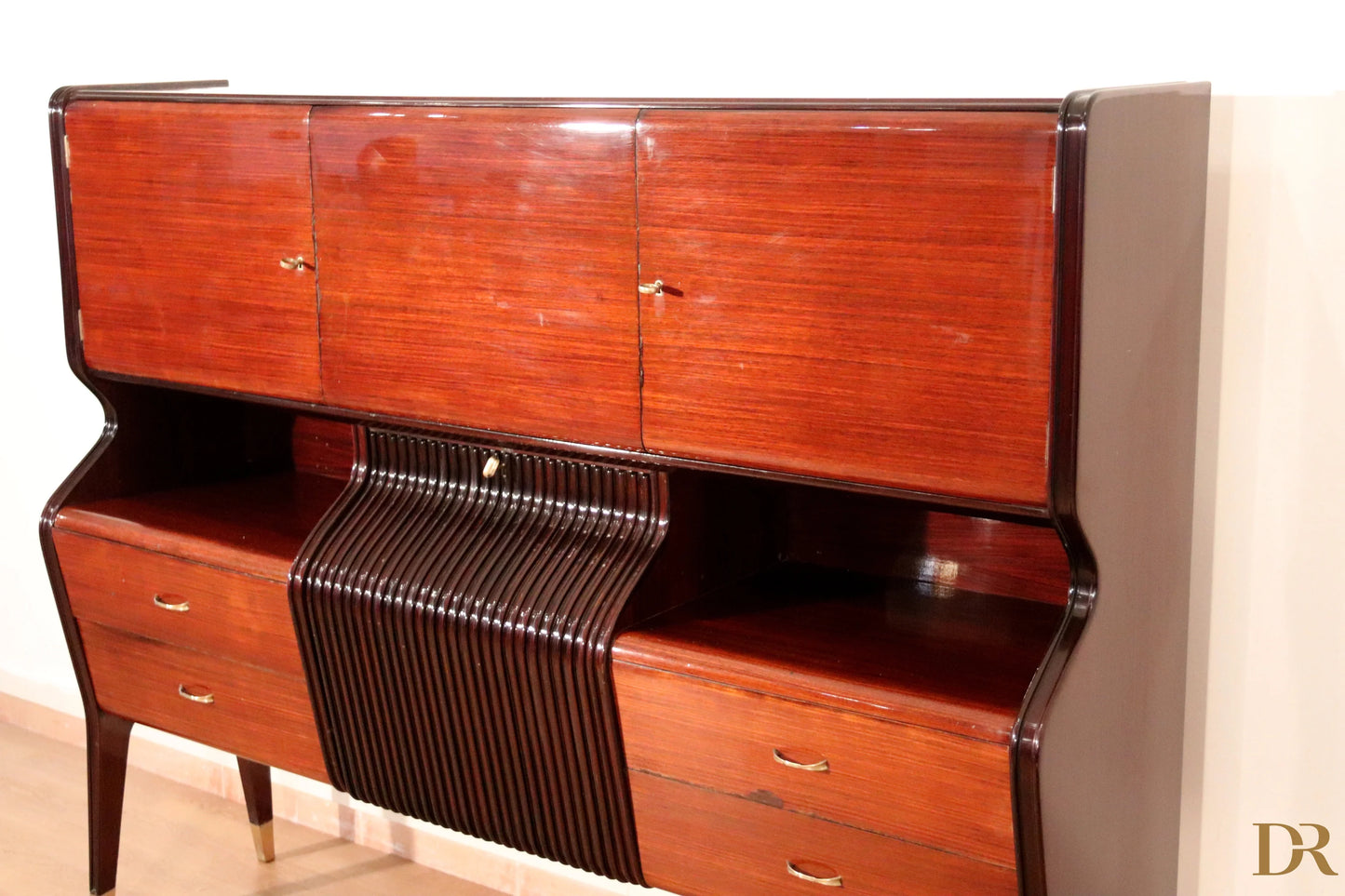 Mid-century sideboard by Osvaldo Borsani in mahogany, rosewood and maple with a curved central panel and brass handles.