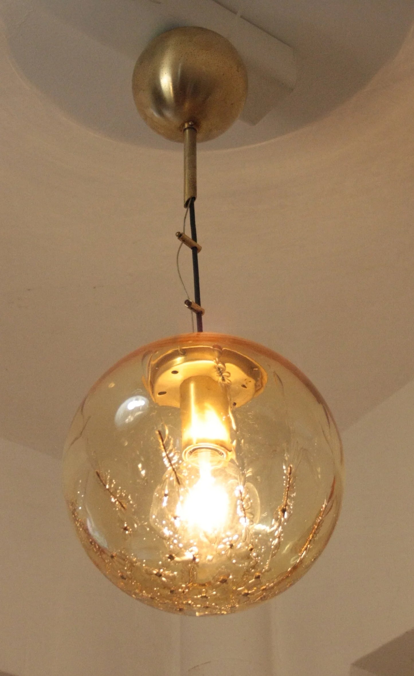 Pendant lamp with spherical pendant in amber glass and brass, signed by Italian design from the 1970s.