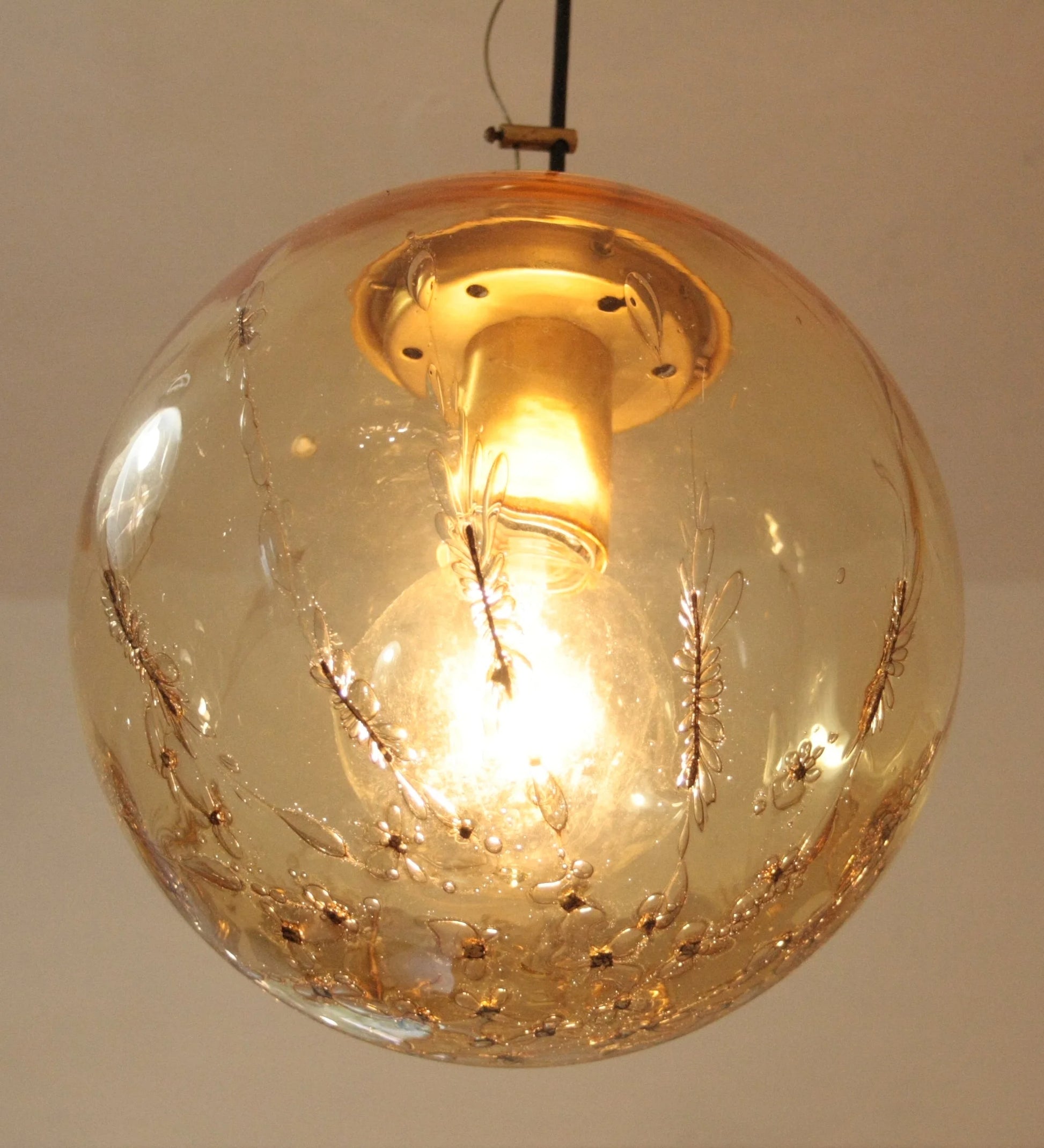 Italian design pendant lamp with a spherical pendant in amber glass and brass, signed by La Murrina from the 1970s.