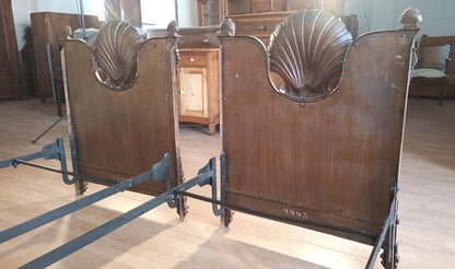 Antique wooden theater chairs with shell carvings on the backrest in the 19th century Italian wrought iron bed