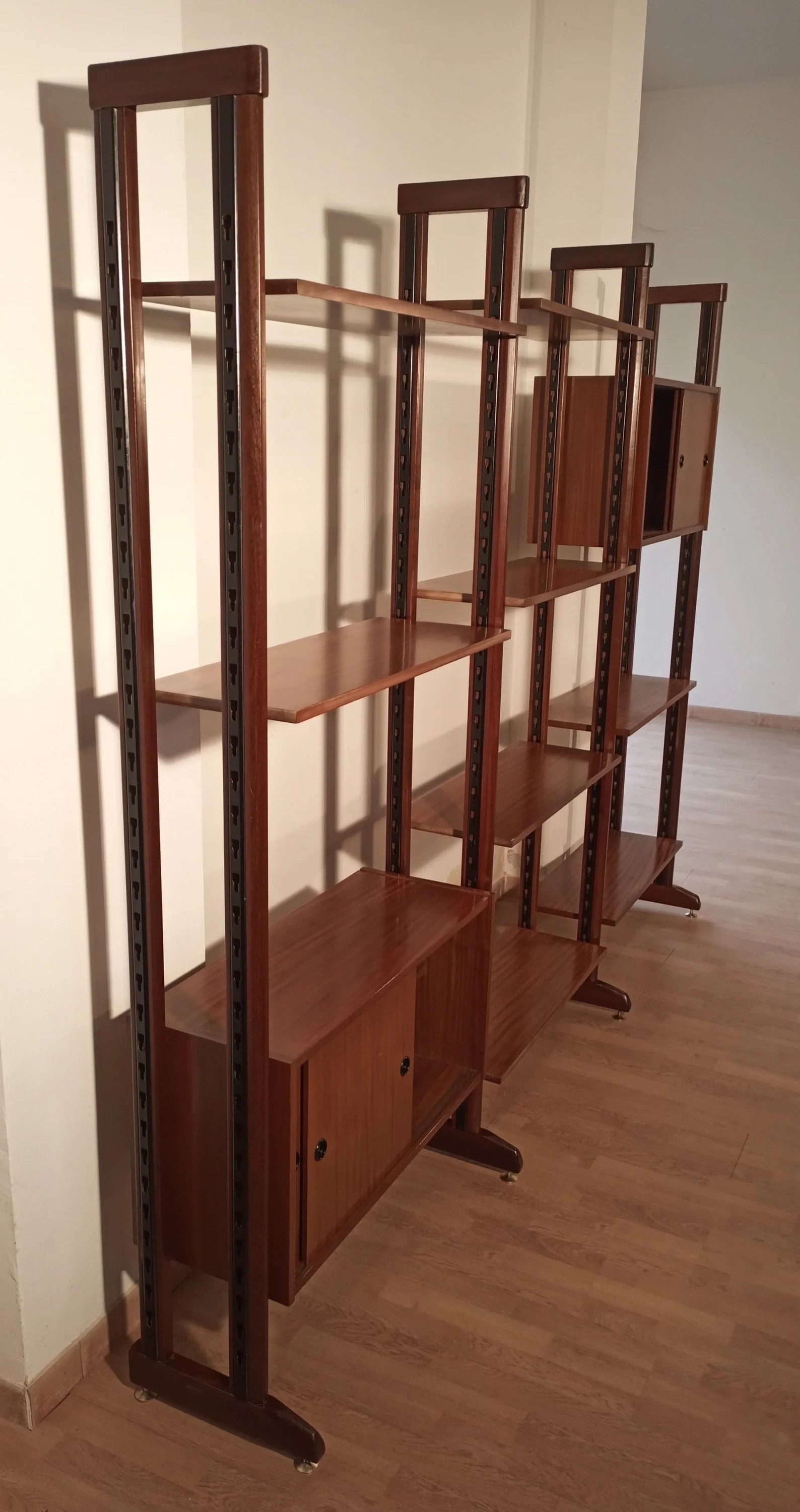 Modern modular vintage teak bookcase with vertical supports and multiple display levels, 1960s Italy