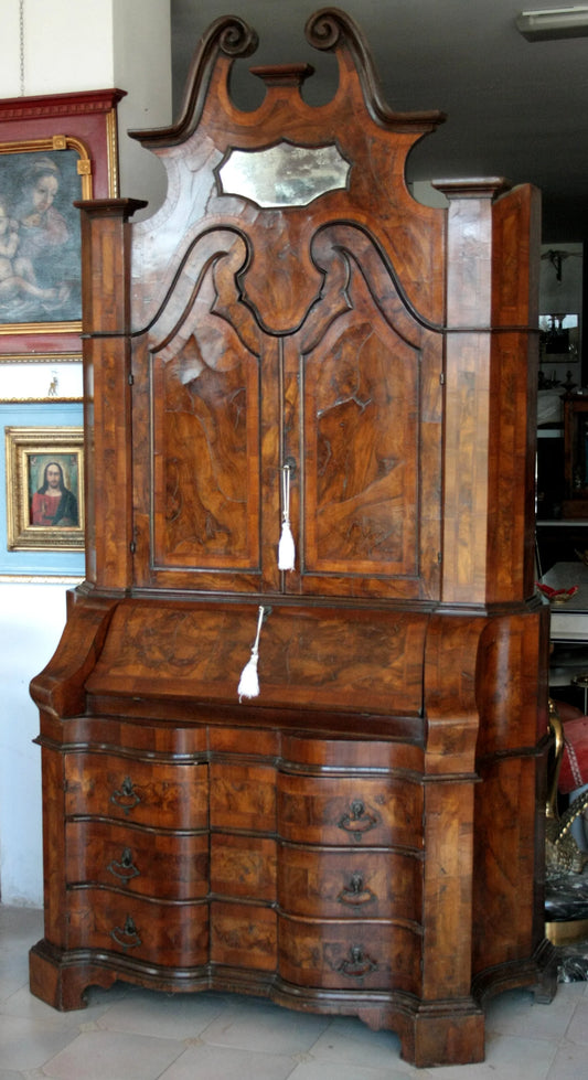 Original Lombard trumeau in walnut and briar with elegant trapezoidal line and wavy body featuring sculpted details and mirror