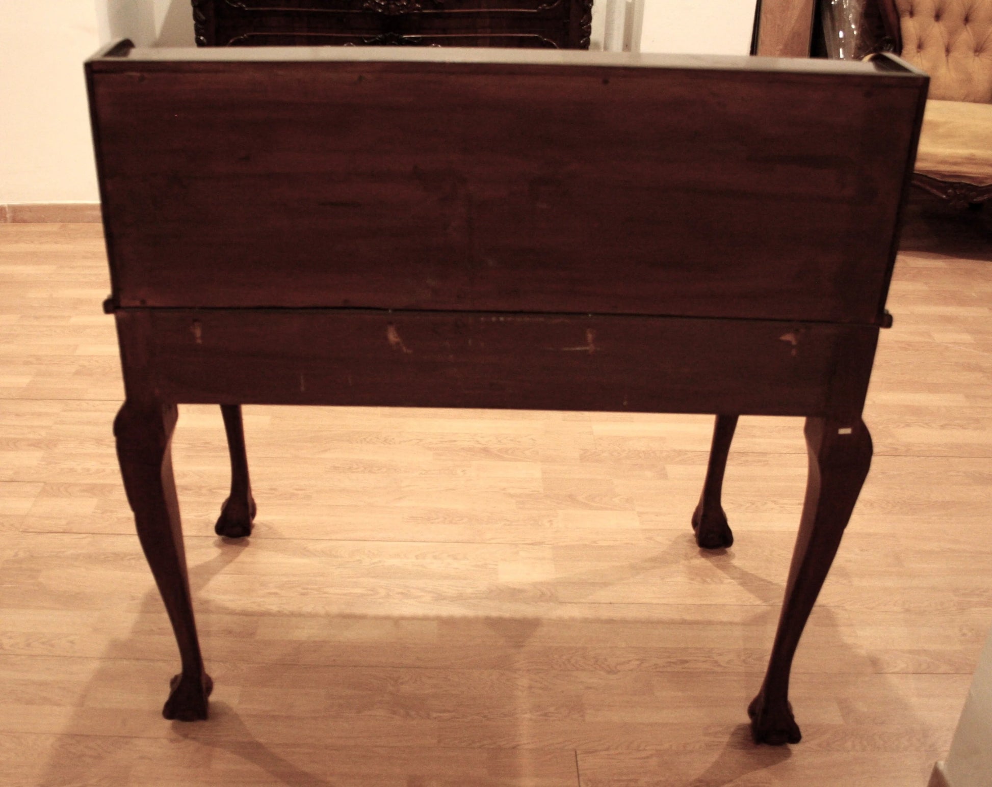 Dark wooden writing desk in English Chippendale style with walnut secretaire, arched legs and claw feet