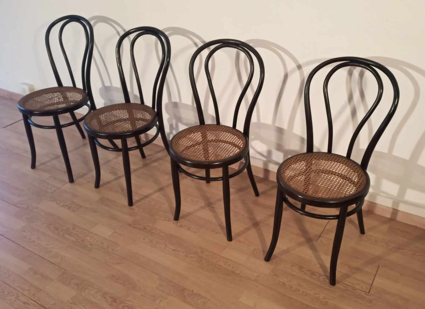 Set of 4 Thonet Italia dining chairs in bent beech with Vienna straw seat arranged in a row