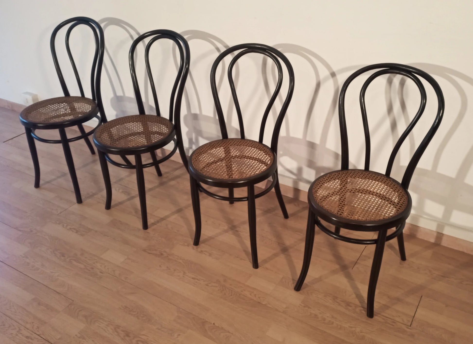 Set of 4 Thonet Italia dining chairs in bent beech with Vienna straw seat arranged in a row
