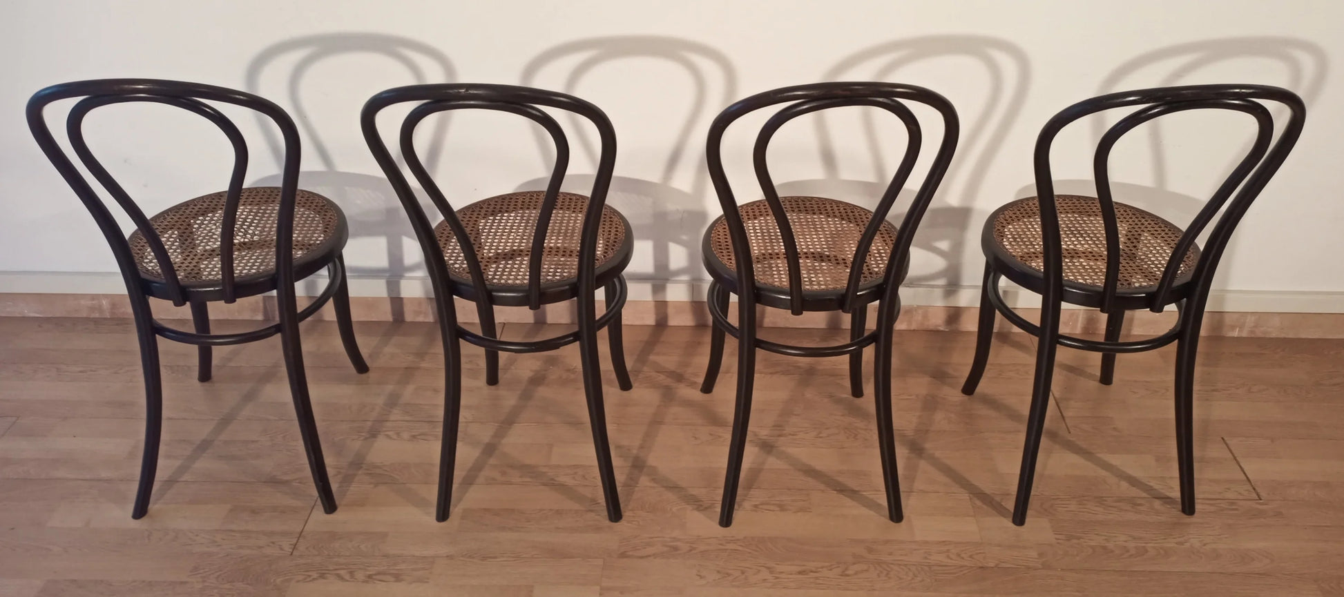 Set of 4 Thonet Italia style bentwood dining chairs with cane seats arranged in a row