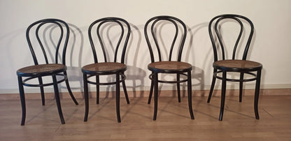 Four black bent beech dining chairs in the Thonet Italia style set arranged in a row