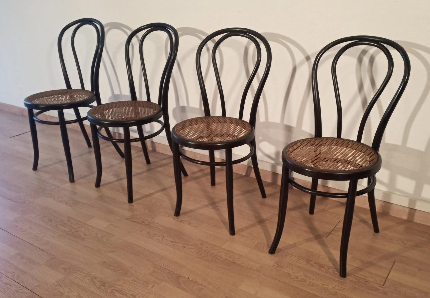 Set of 4 black bent beech dining chairs in the Thonet Italian style with woven straw seats