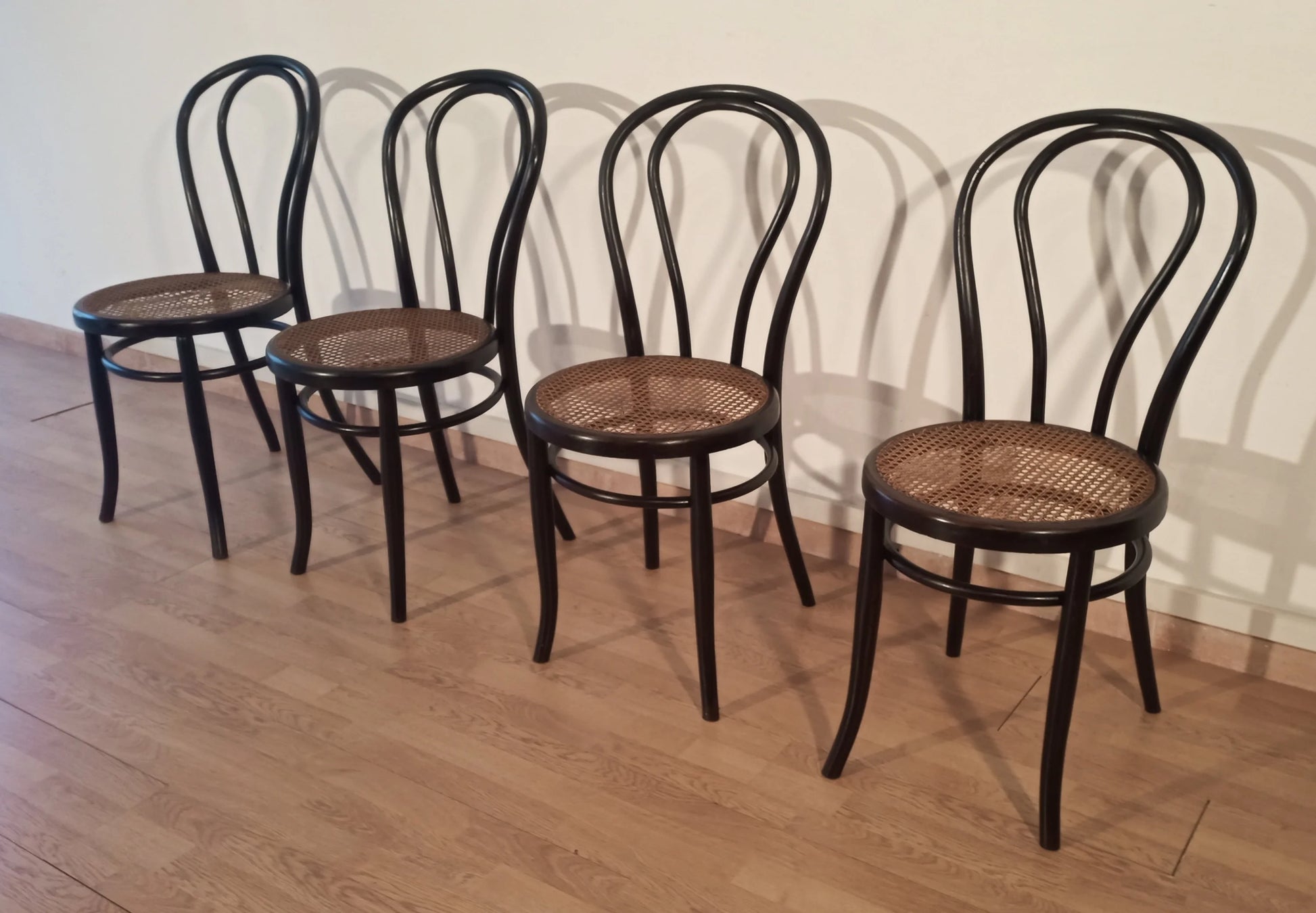 Set of 4 black bent beech dining chairs in the Thonet Italian style with woven straw seats