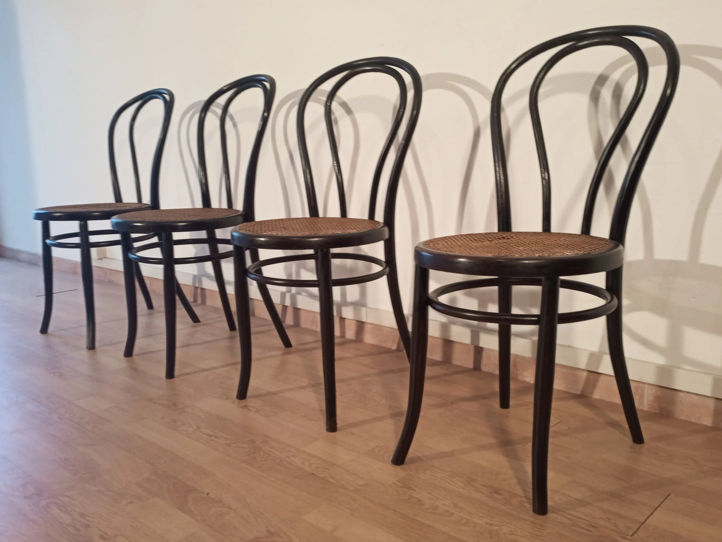 Set of 4 Thonet Italia dining chairs in black bent beech with wooden seat arranged in a row