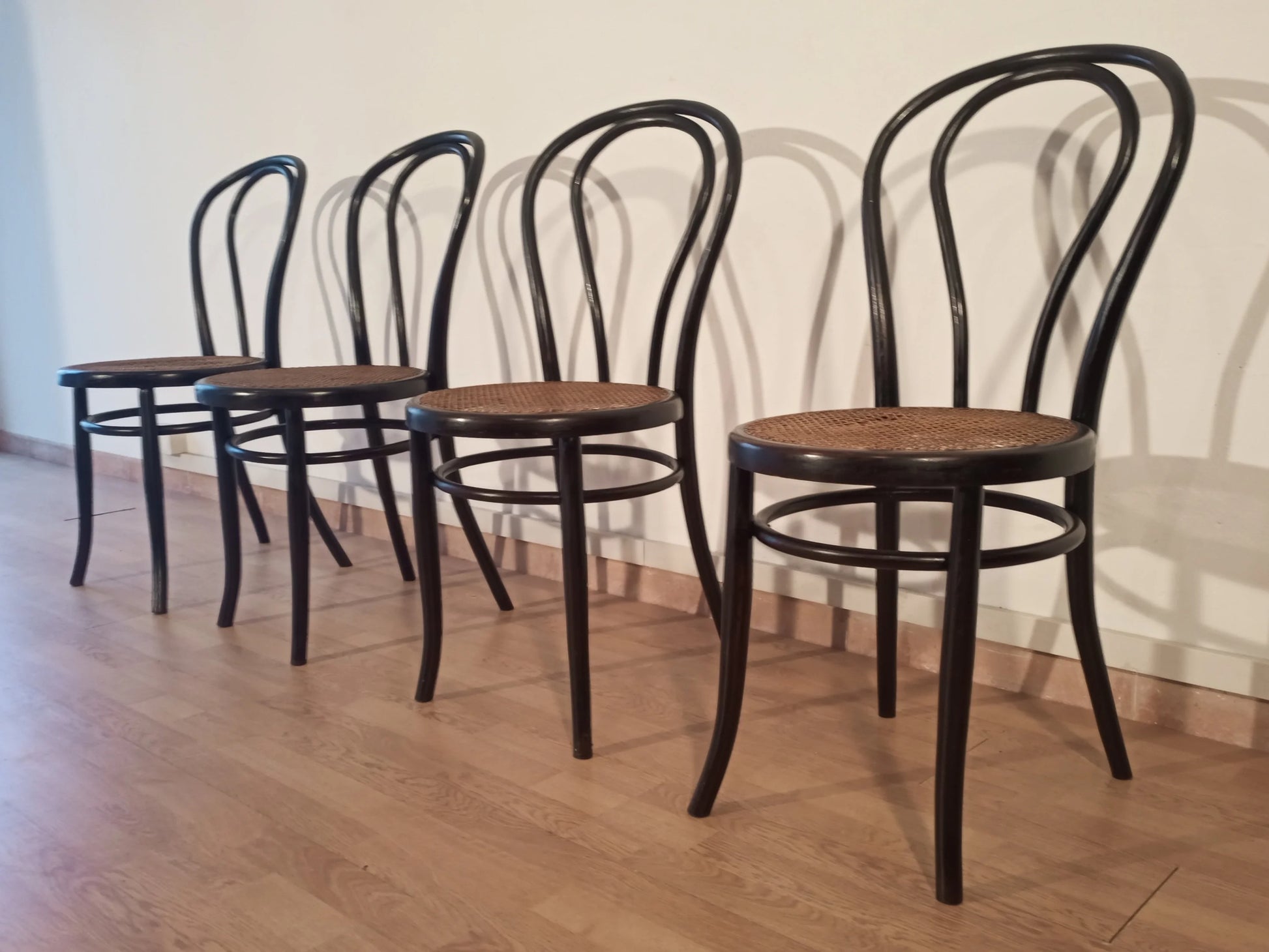Set of 4 Thonet Italia dining chairs in black bent beech with wooden seat arranged in a row