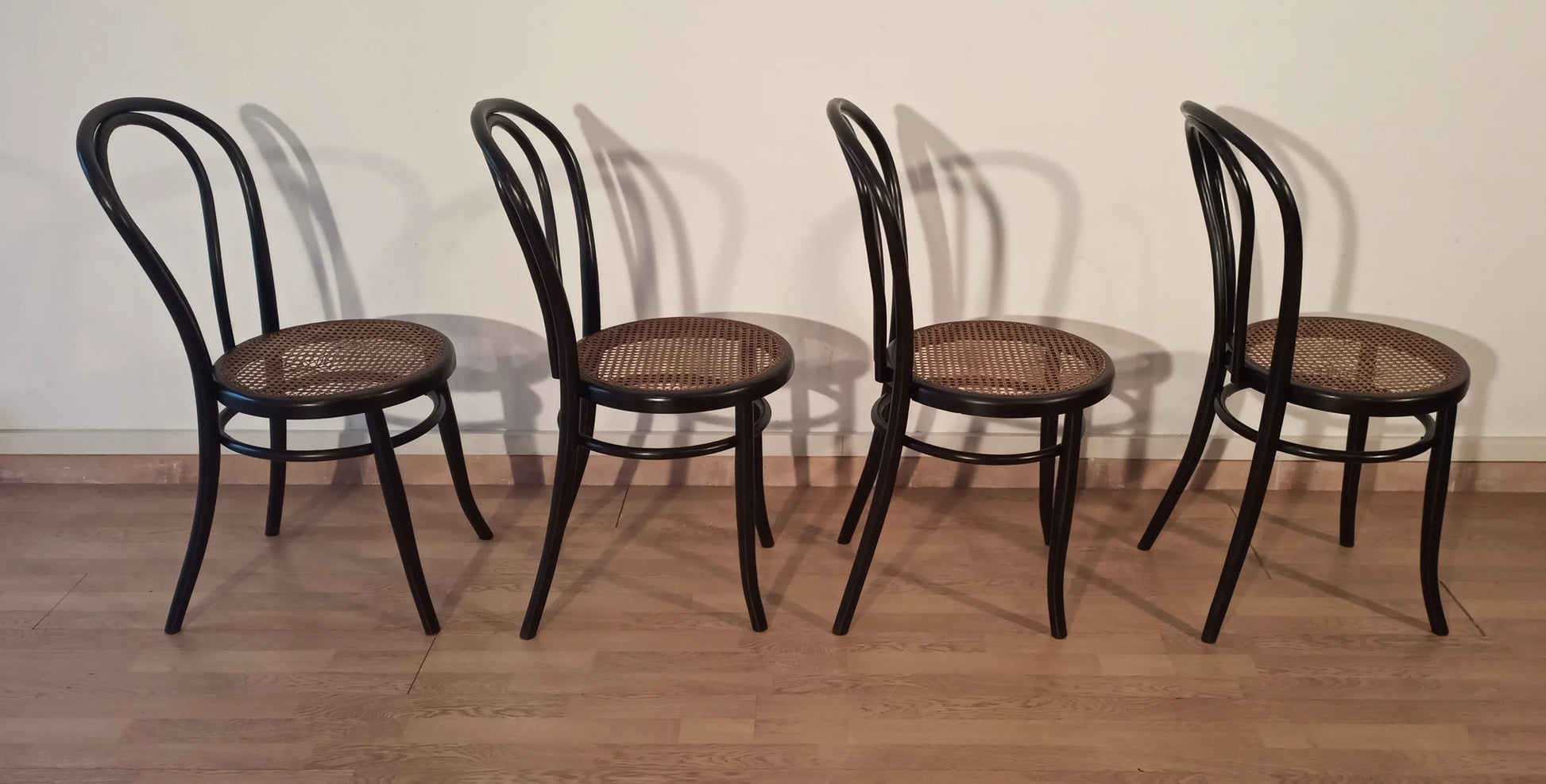 Black bentwood dining chairs with cane seat, Thonet Italia set of 4.