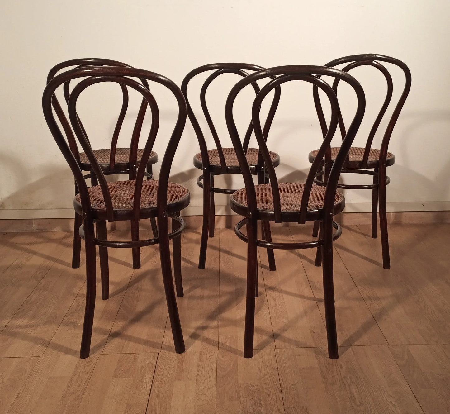 Set of four Thonet Drava style chairs with woven straw seats and black bentwood frame