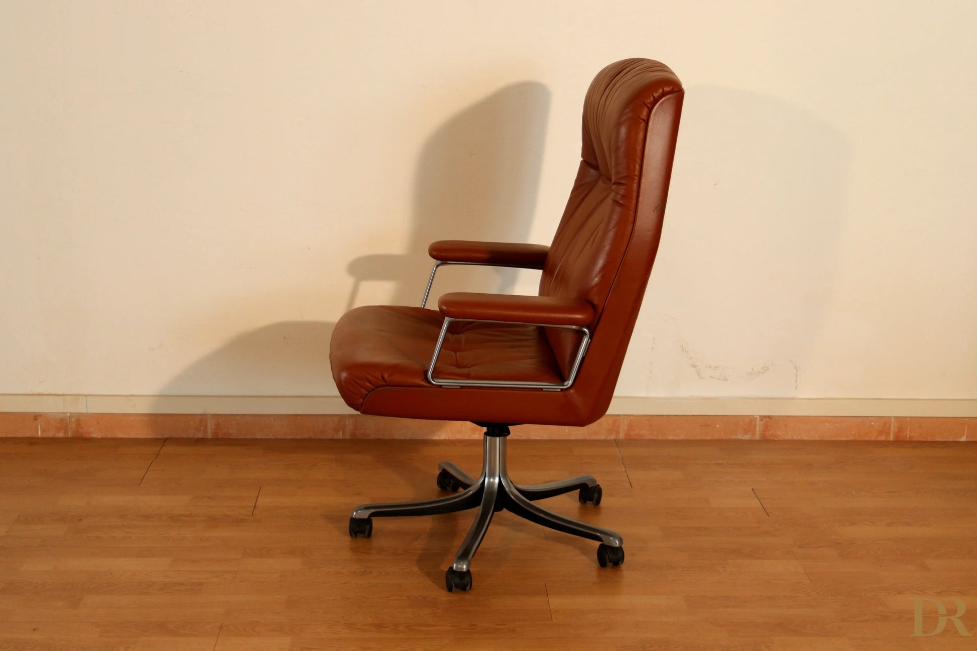 The Tecno P126 office chair in brown leather with chrome armrests and a five-star base combines industrial aesthetics.