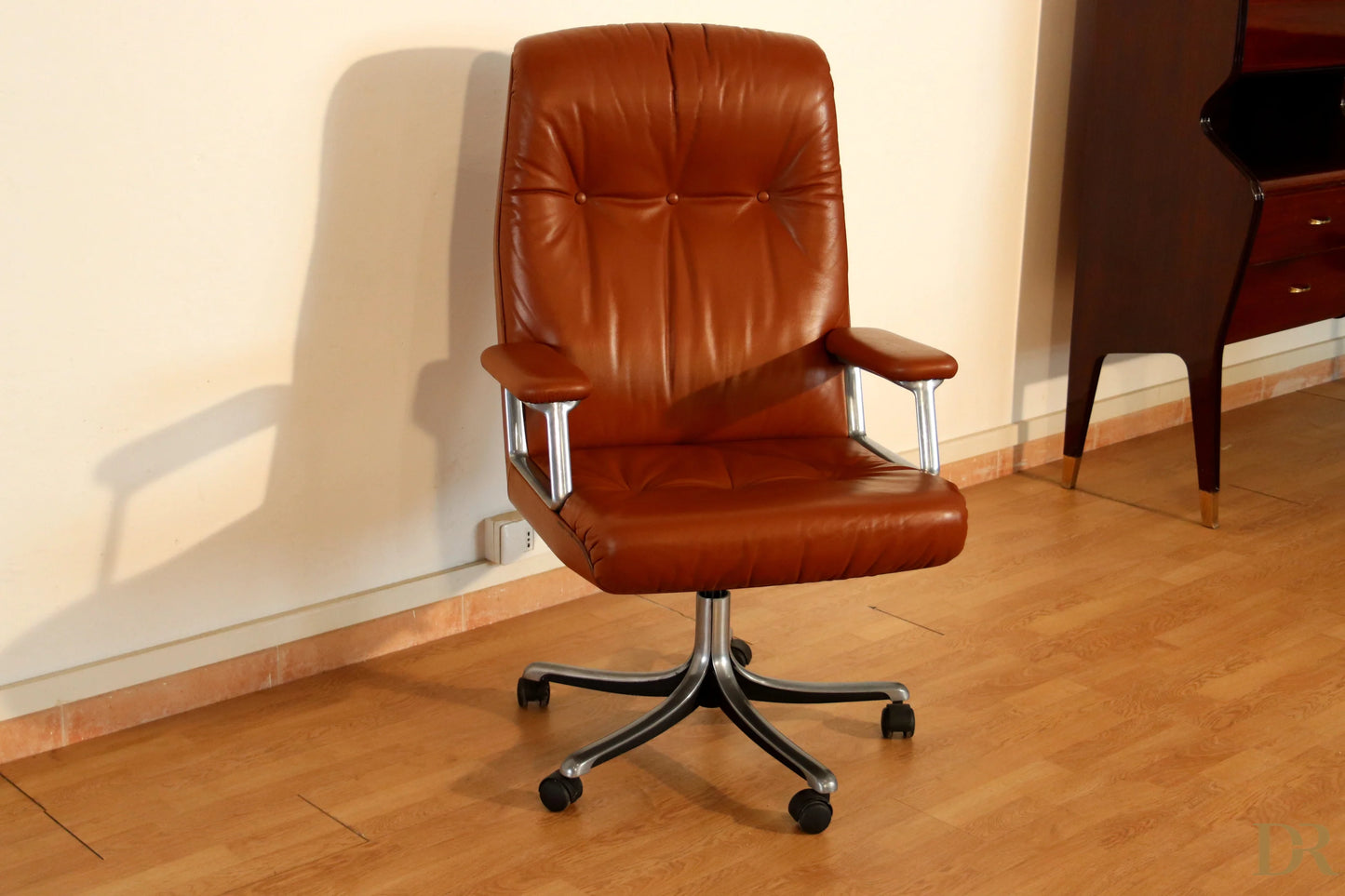 The Tecno P126 executive office chair in brown leather with armrests and chrome base combines industrial aesthetics.