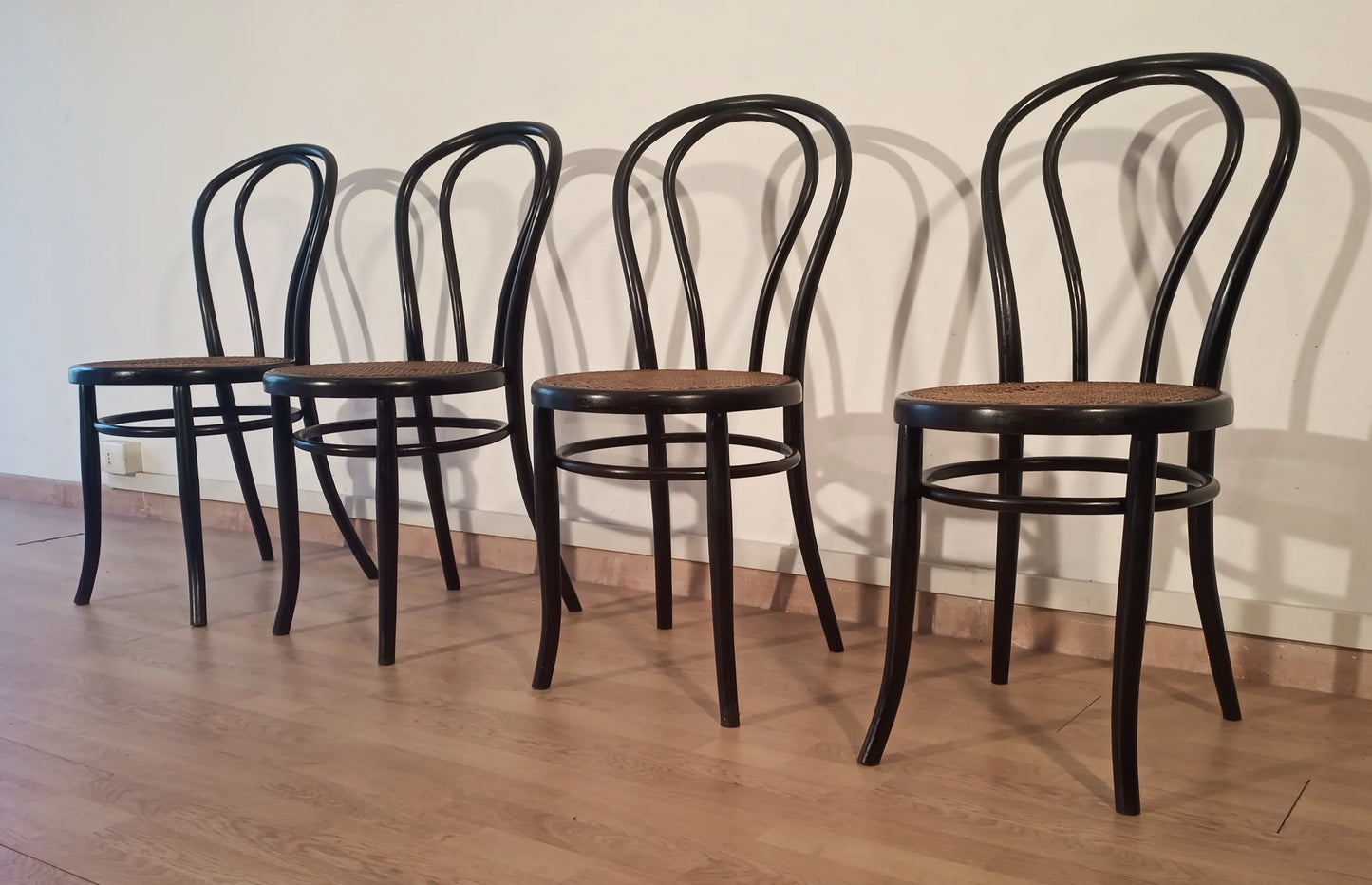 Set of 4 Thonet Italia style bent beech dining chairs with curved backrests and wooden seats arranged in a row