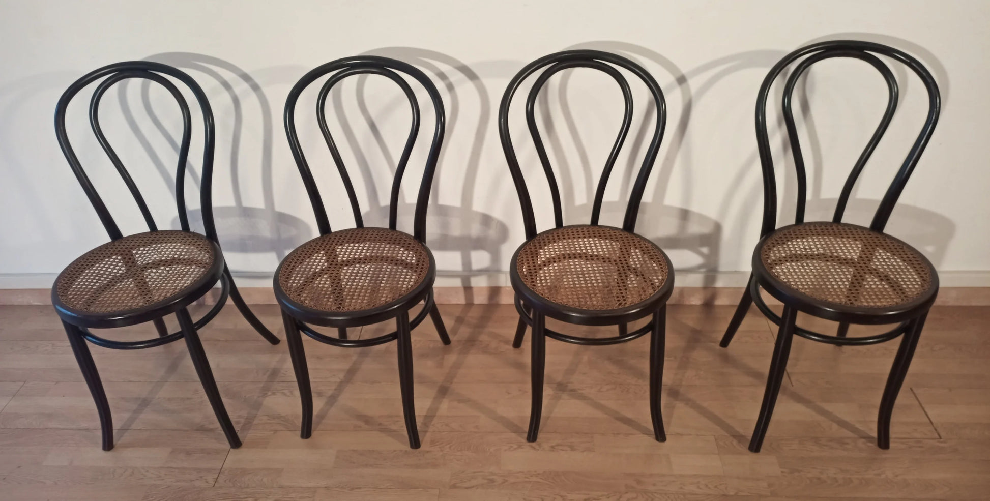 Set of 4 dining chairs in bent beech with cane seat in the Thonet Italia style arranged in a row