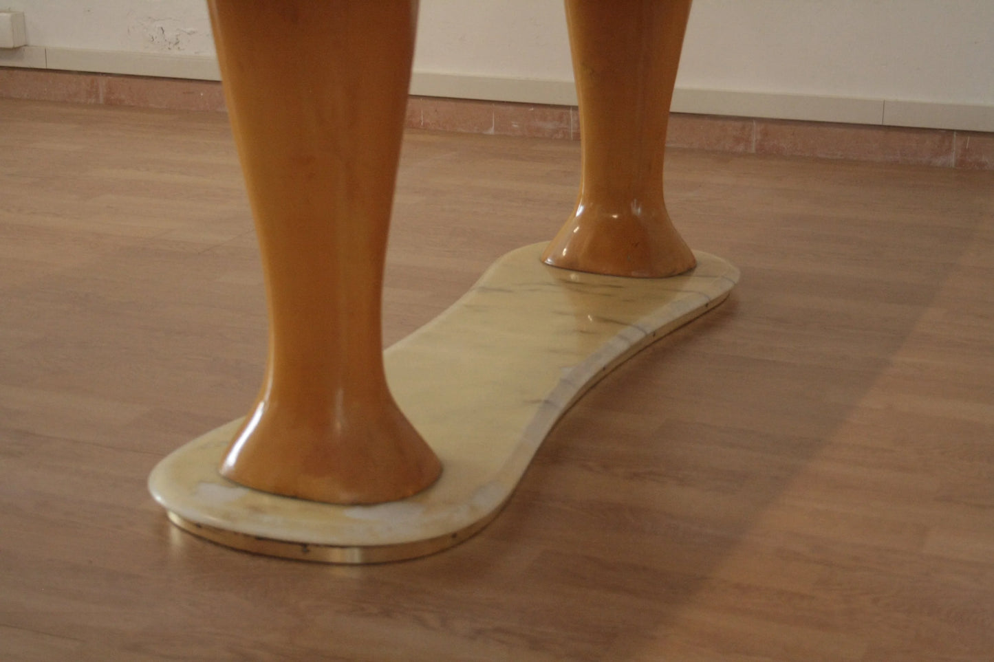 Shiny orange mannequin legs on wooden base displayed with tavolo da pranzo mid-century moderno di vittorio dassi